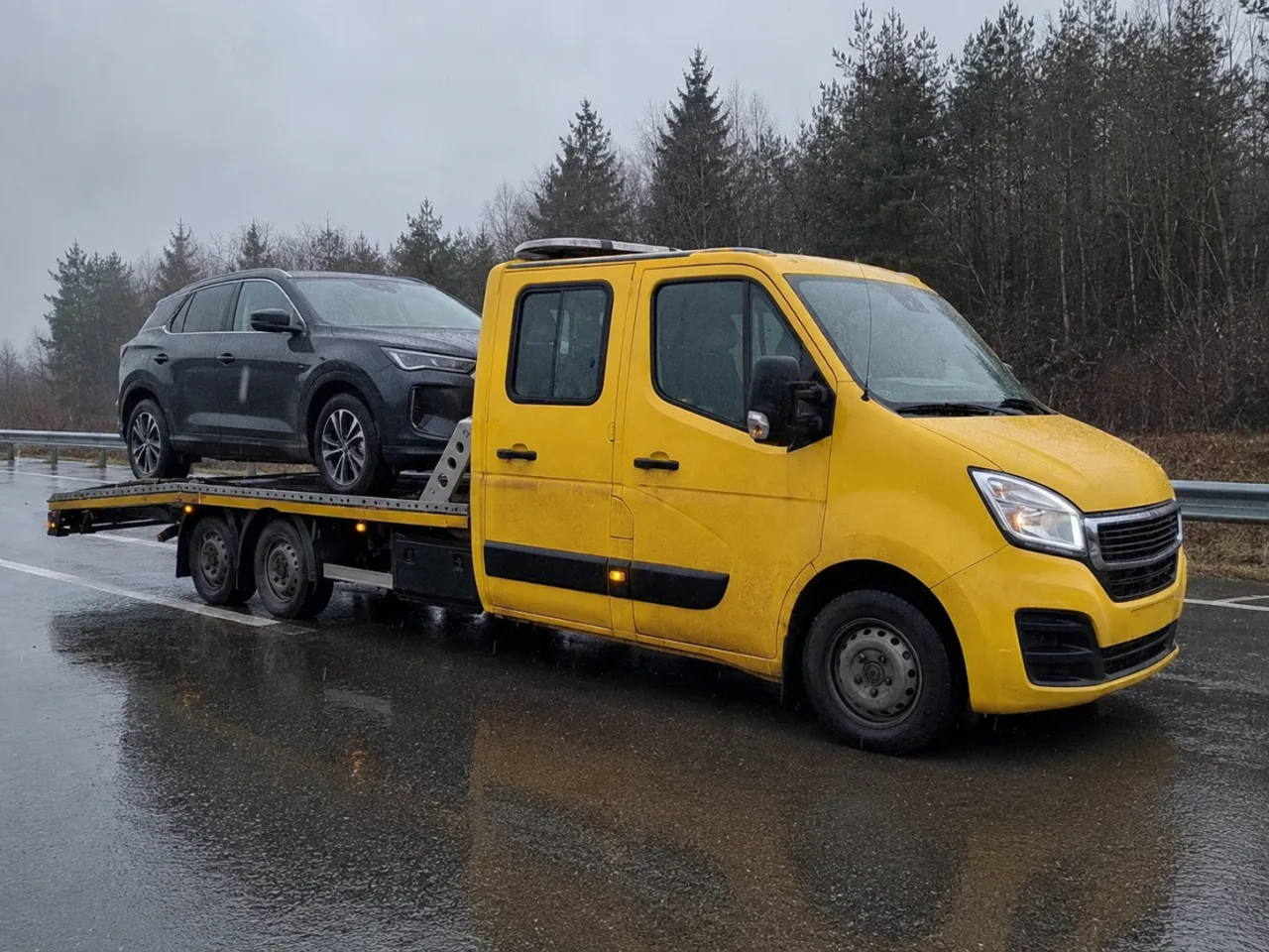 Srebrny SUV na platformie lawety podczas deszczu – holowanie Pabianice