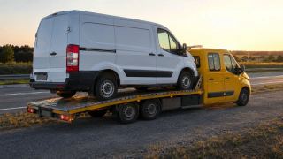 Bus przewożony lawetą o zmierzchu – Pabianice, wylot na Rzgów