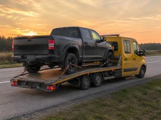 Pickup na lawecie na tle zachodzącego słońca – transport maszyn Pabianice